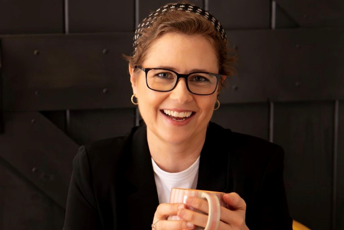 Jenna Fischer with short hair. She is holding a coffee mug.