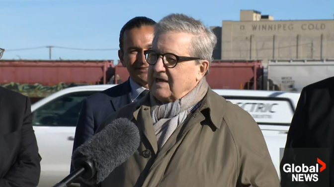 Manitoba Premier Wab Kinew looks on as Lloyd Axworthy speaks to media Tuesday, Oct. 15, 2024.