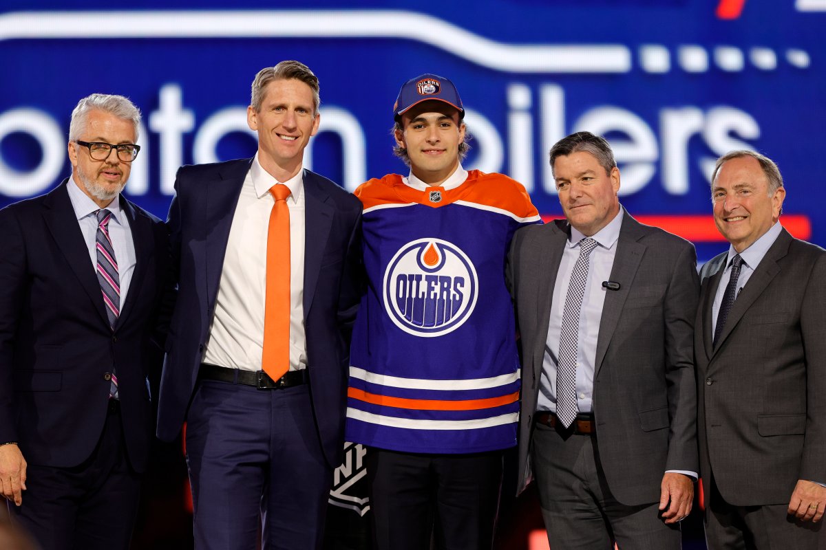 Sam O'Reilly, centre, poses after being selected by the Edmonton Oilers during the first round of the NHL hockey draft Friday, June 28, 2024, in Las Vegas.