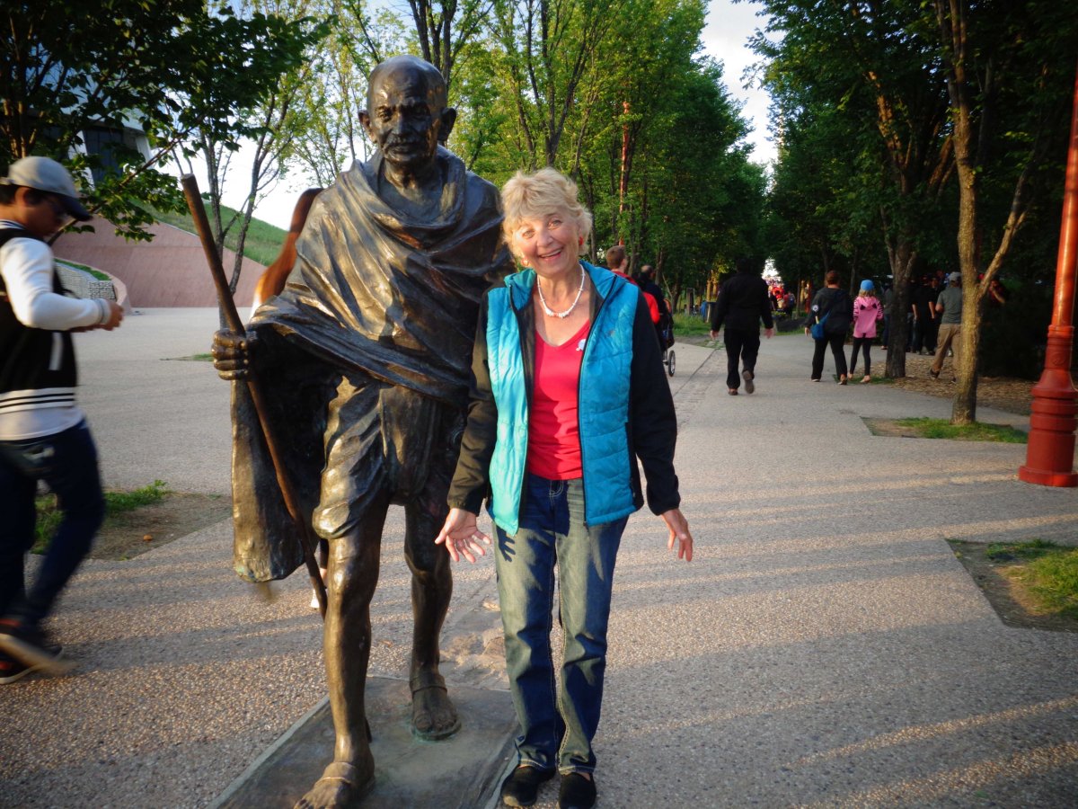 Ywanna (Jean) Backman standing by a statue of Mahatma Gandhi.