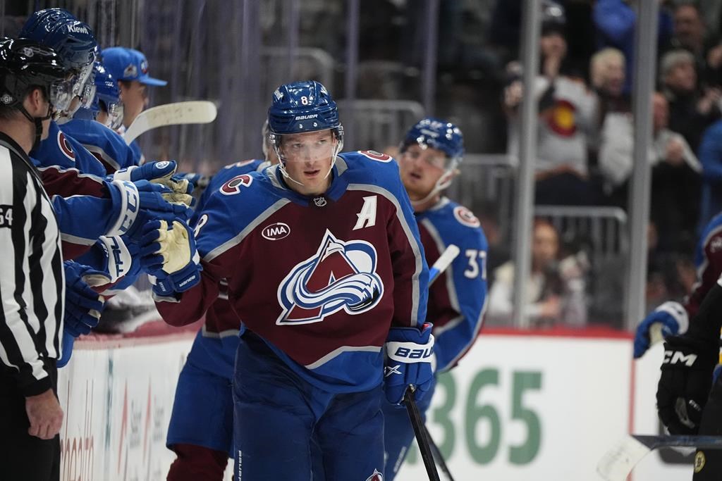 Colorado Avalanche defenceman Cale Makar is congratulated as he passes the team box after scoring a goal in the second period of an NHL hockey game against the Boston Bruins Wednesday, Oct. 16, 2024, in Denver.