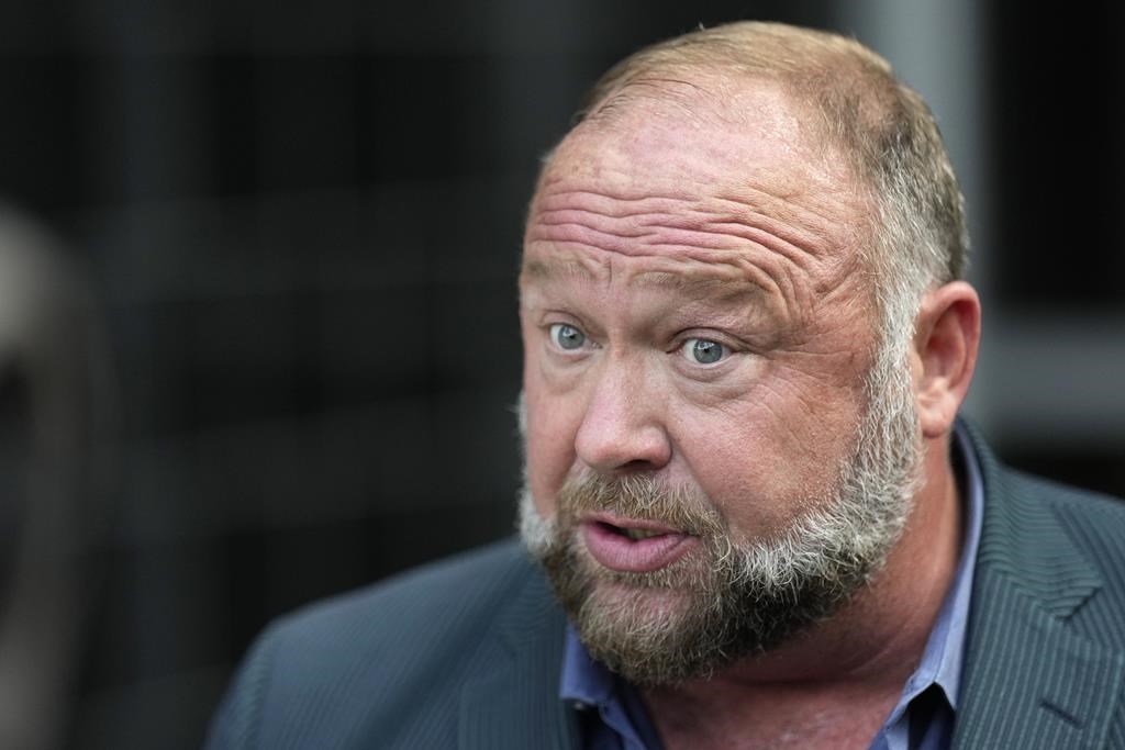 FILE - Right-wing conspiracy theorist Alex Jones speaks to the media after arriving at the federal courthouse for a hearing in front of a bankruptcy judge Friday, June 14, 2024, in Houston.