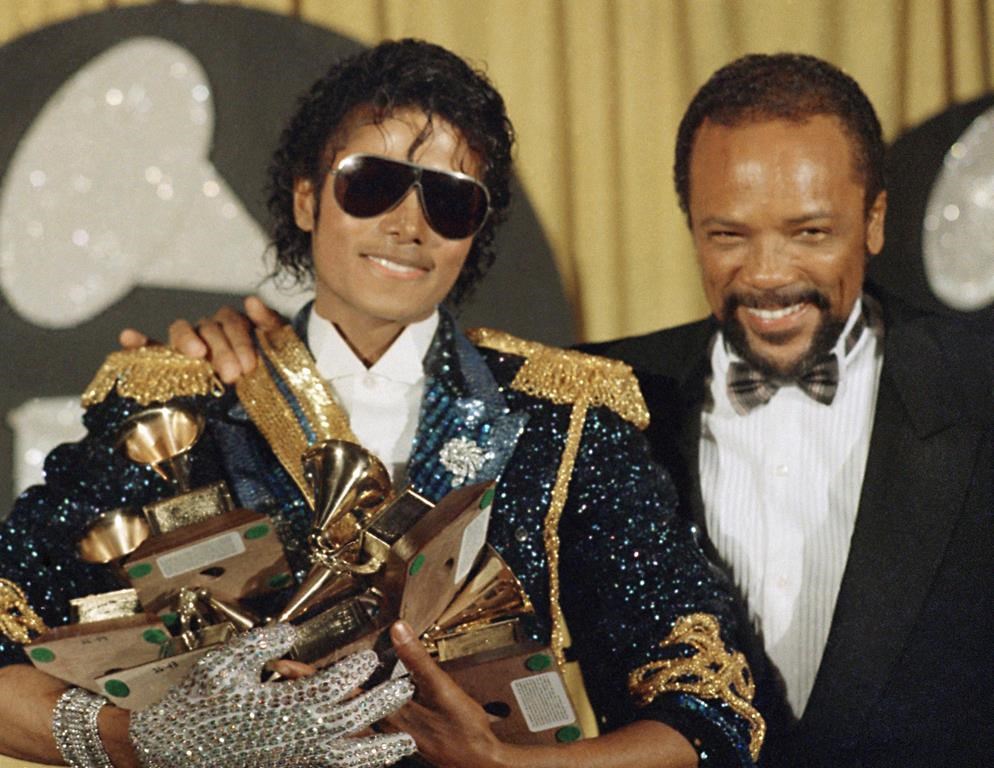 FILE - Michael Jackson, left, holds eight awards as he poses with Quincy Jones at the Grammy Awards in Los Angeles, Feb. 28, 1984. Quincy Jones died at age 91.