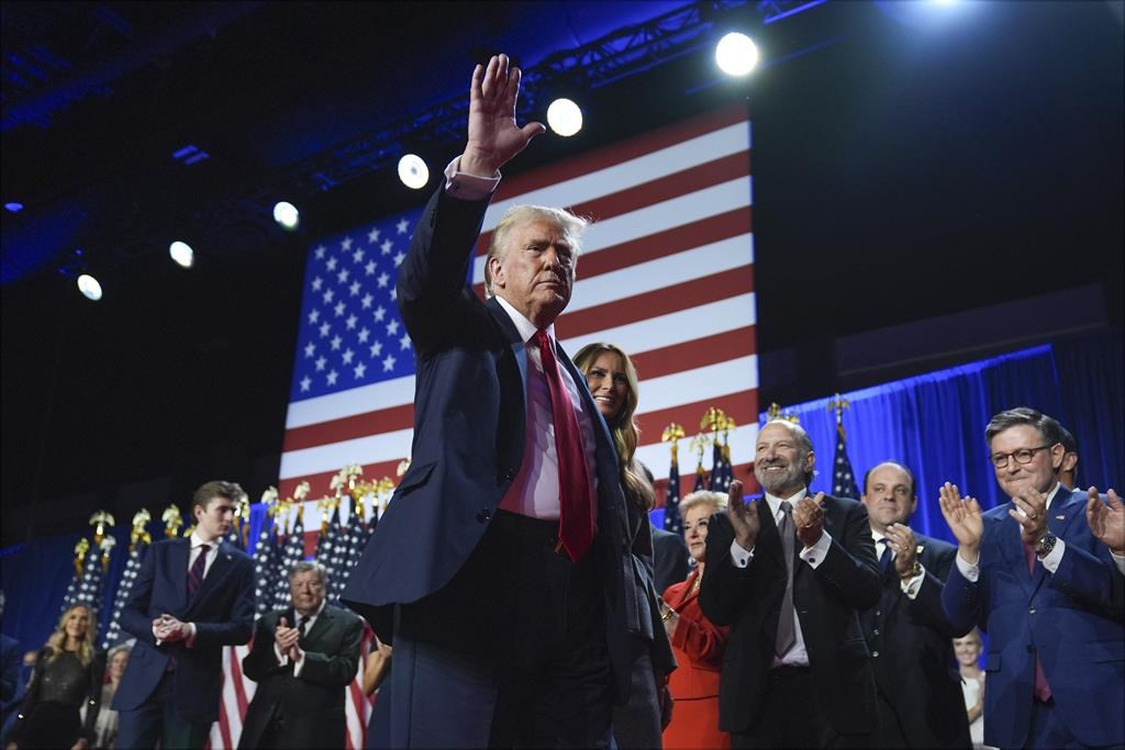Republican presidential and nominee former president Donald Trump waves as he walks with his wife Melania Trump at an election night watch party at the Palm Beach Convention Center, Wednesday, Nov. 6, 2024, in West Palm Beach, Fla.