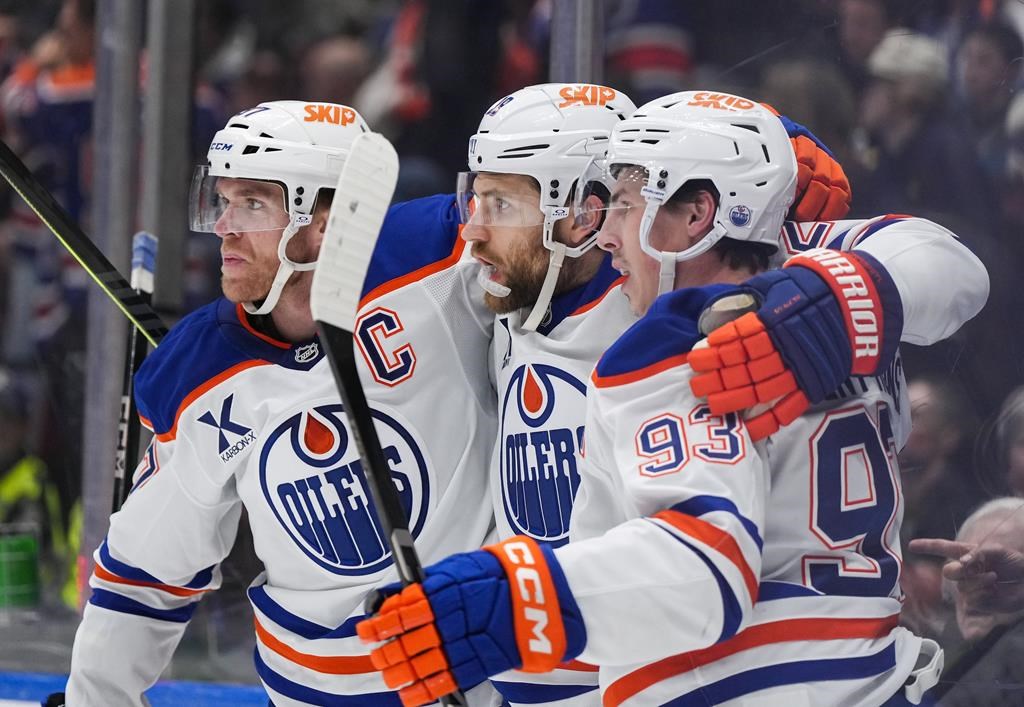 Edmonton Oilers' Connor McDavid, from left to right, Leon Draisaitl and Ryan Nugent-Hopkins celebrate Draisaitl's goal against the Vancouver Canucks during the first period of an NHL hockey game in Vancouver, on Saturday, November 9, 2024.