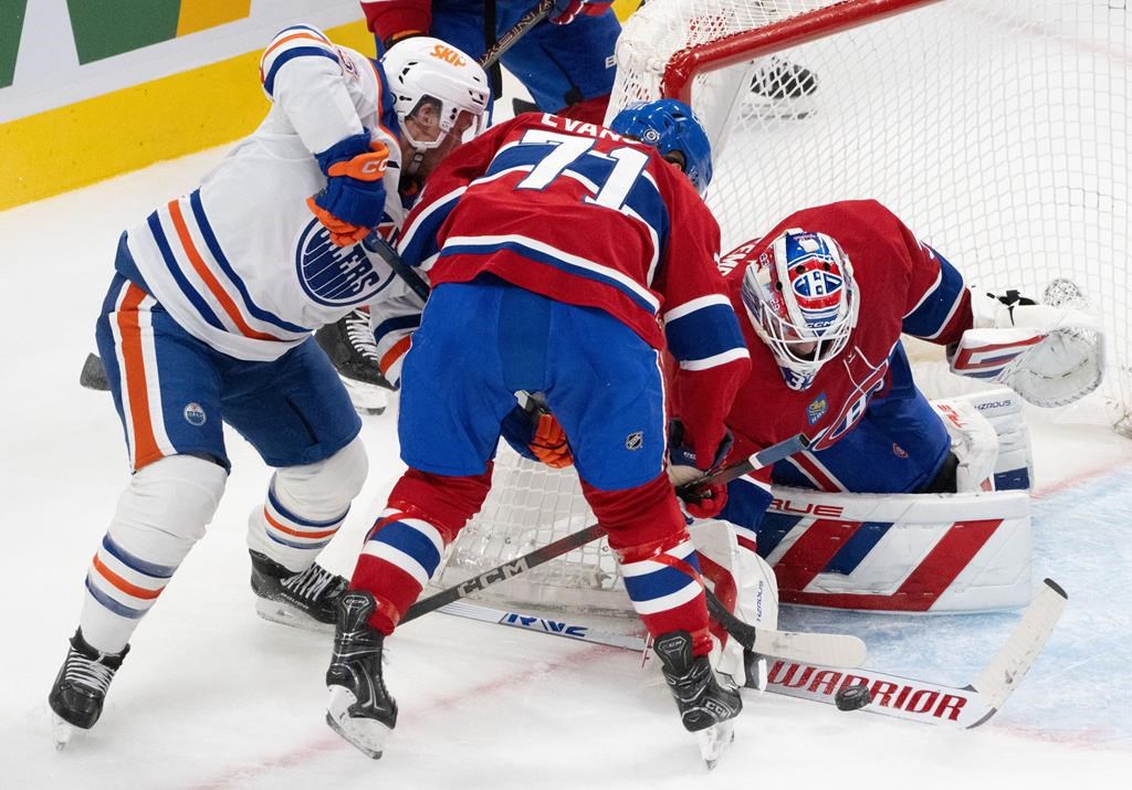 Montreal Canadiens' goaltender Sam Montembeault (35) stops a shot as Edmonton Oilers' Jeff Skinner (53) and Canadiens' Jake Evans (71) look for the rebound during second period NHL hockey action in Montreal, Monday, Nov. 18, 2024. THE CANADIAN PRESS/Christinne Muschi.