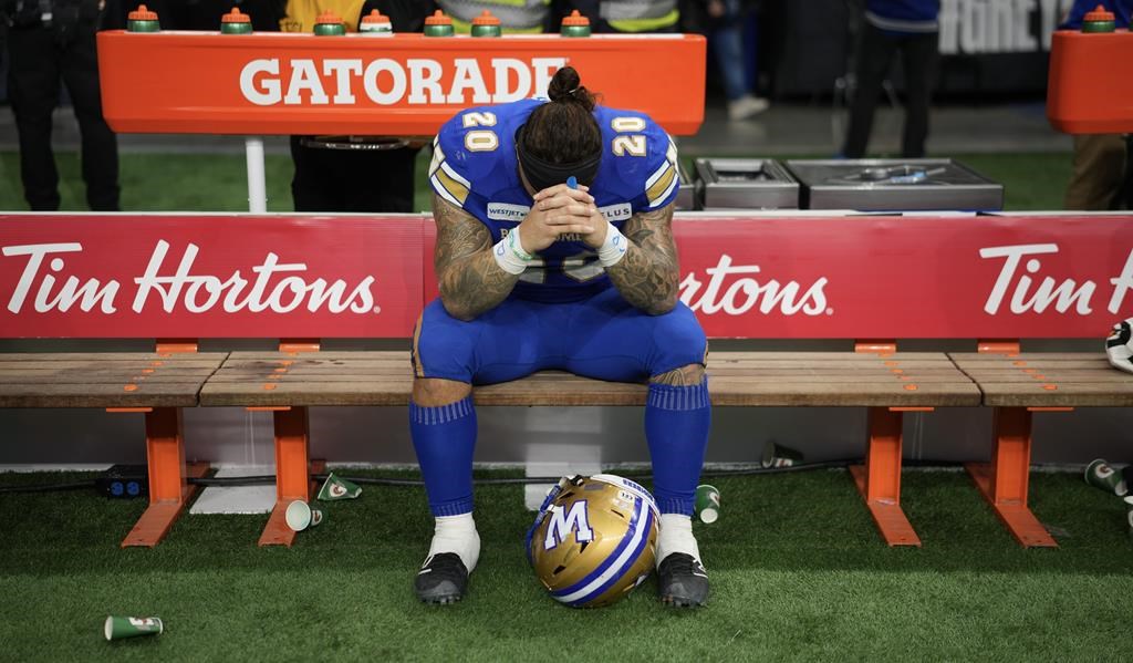 Winnipeg Blue Bombers' Brady Oliveira (20) reacts from the bench after losing the 111th Grey Cup to the Toronto Argonauts, in Vancouver, B.C., Sunday, Nov. 17, 2024. There was no anger in Brady Oliveira’s voice when the Winnipeg Blue Bombers star running back answered questions Tuesday about a hot topic that lingers after the Grey Cup. THE CANADIAN PRESS/Ethan Cairns.