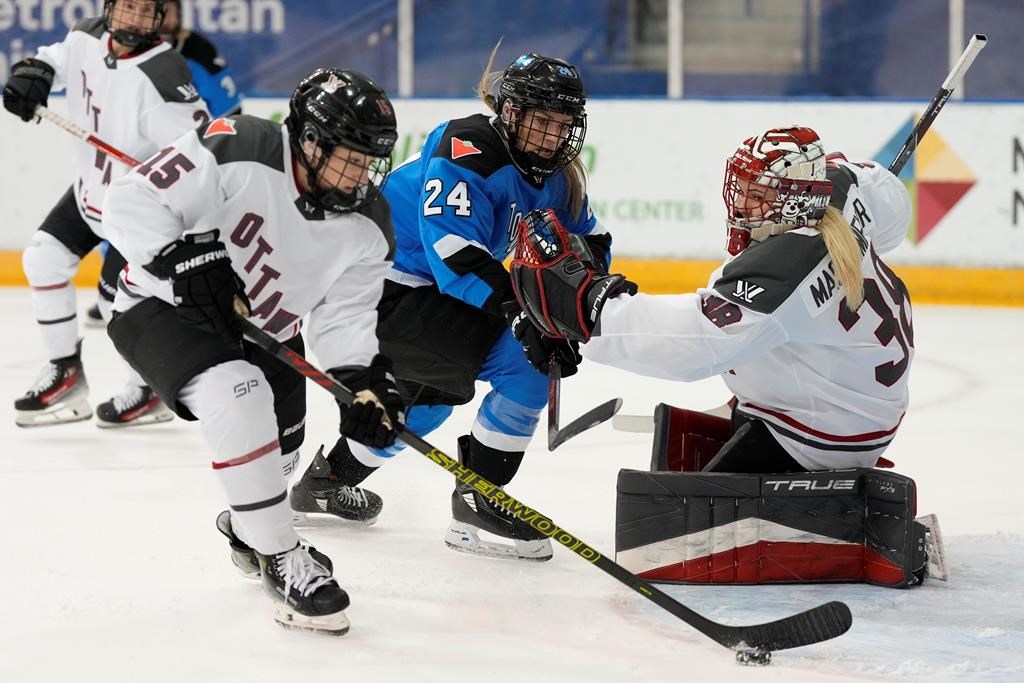 Ottawa goalie Emerance Maschmeyer and Toronto's Natalie Spooner look on as Ottawa's Savannah Harmon clears the puck during PWHL action in Toronto on Sunday May 5, 2024.