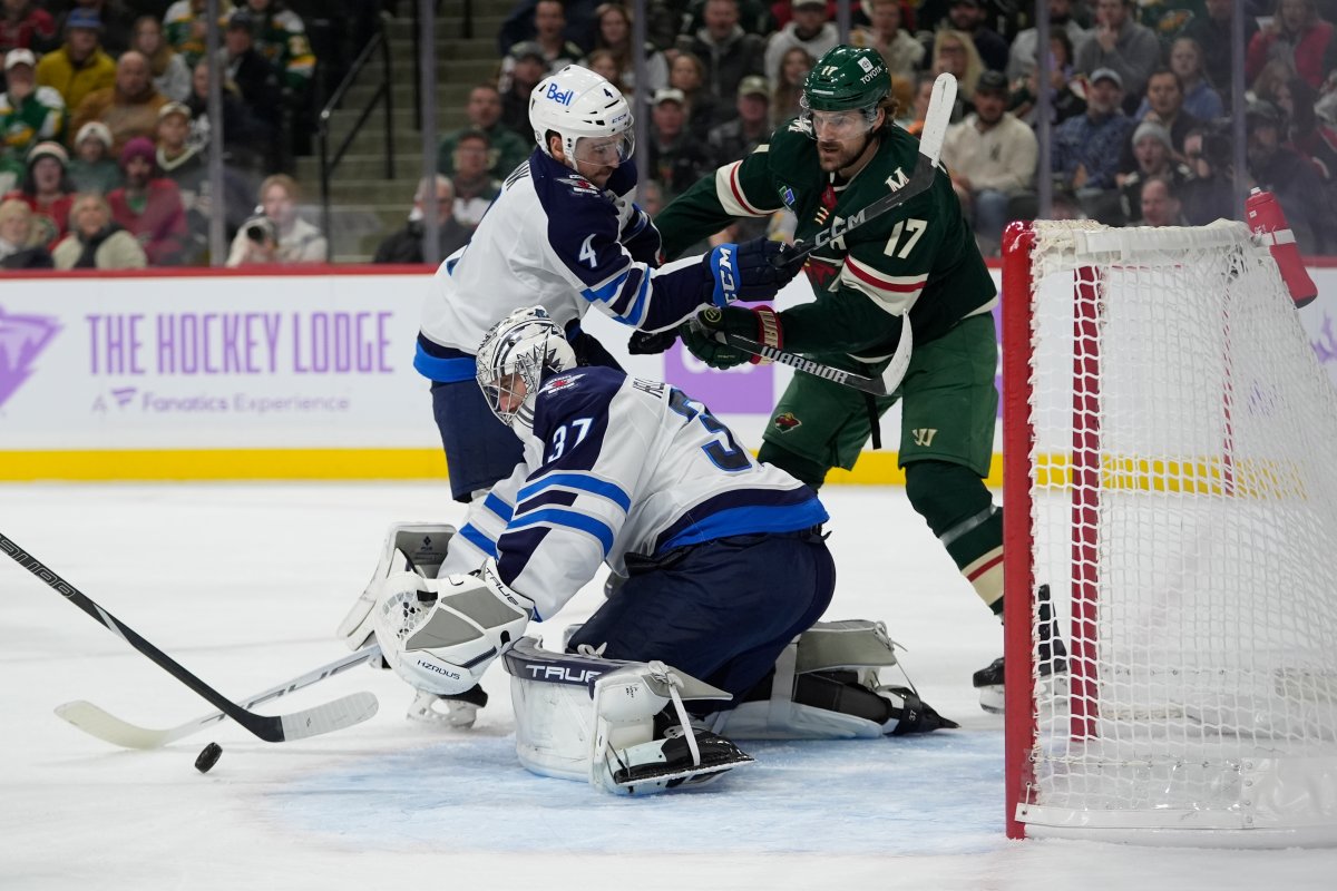 Winnipeg Jets goaltender Connor Hellebuyck (37) stops a shot during the first period of an NHL hockey game against the Minnesota Wild, Monday, Nov. 25, 2024, in St. Paul, Minn. (AP Photo/Abbie Parr).