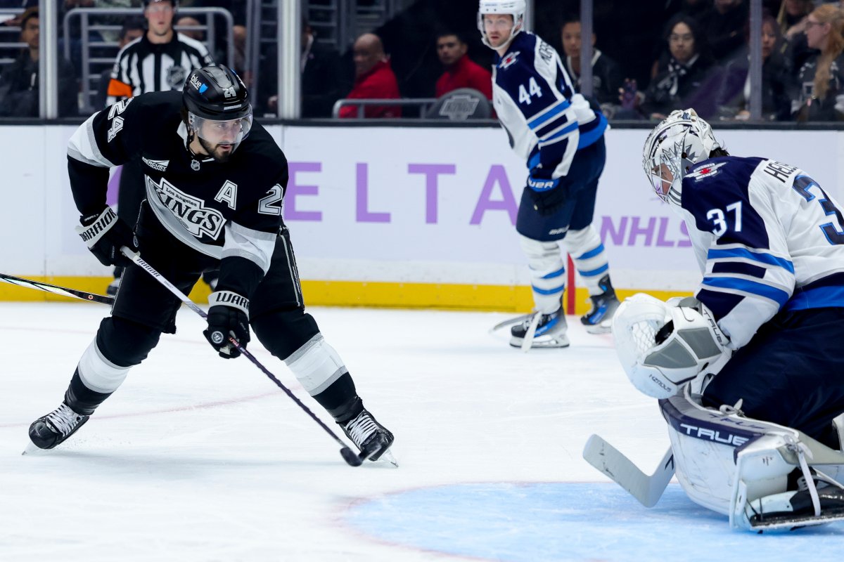 Los Angeles Kings center Phillip Danault, left, shoots against Winnipeg Jets goaltender Connor Hellebuyck during the second period of an NHL hockey game Wednesday, Nov. 27, 2024, in Los Angeles. (AP Photo/Ryan Sun).