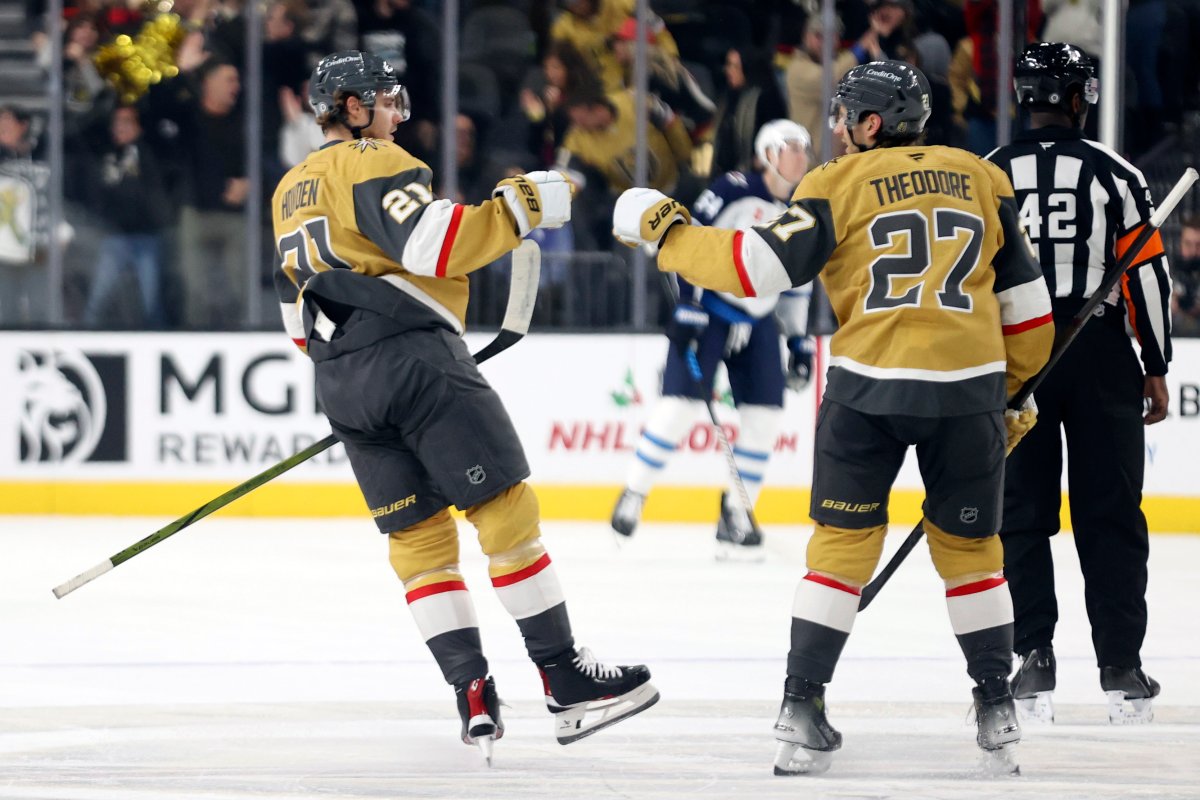 Vegas Golden Knights center Brett Howden (21) and defenseman Shea Theodore (27) celebrate after Howden's goal during the first period of an NHL hockey game against the Winnipeg Jets, Friday, Nov. 29, 2024, in Las Vegas. (AP Photo/Ian Maule).