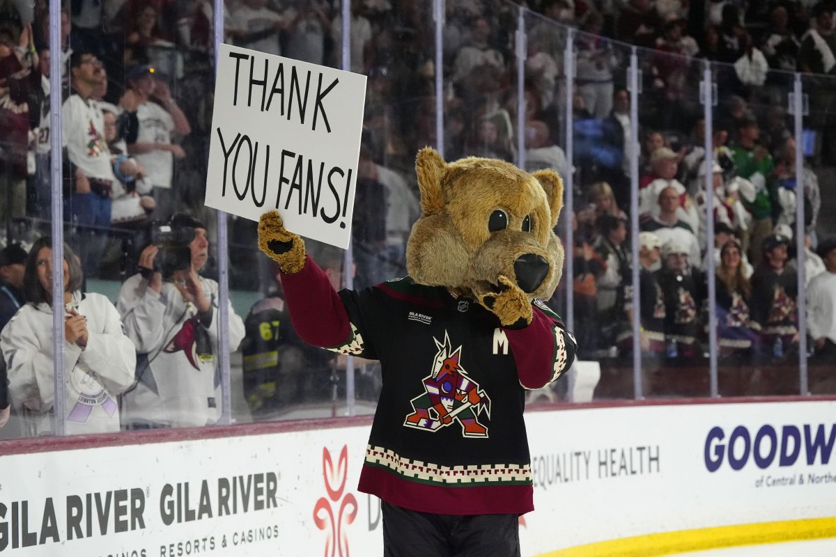 Arizona Coyotes mascot Howler acknowledges holds a sign after the team's NHL hockey game against the Edmonton Oilers on Wednesday, April 17, 2024, in Tempe, Ariz. The Coyotes won 5-2. Team owner Alex Meruelo agreed to sell franchise's hockey operations to Utah Jazz owner Ryan Smith, who moved the team to Salt Lake City.