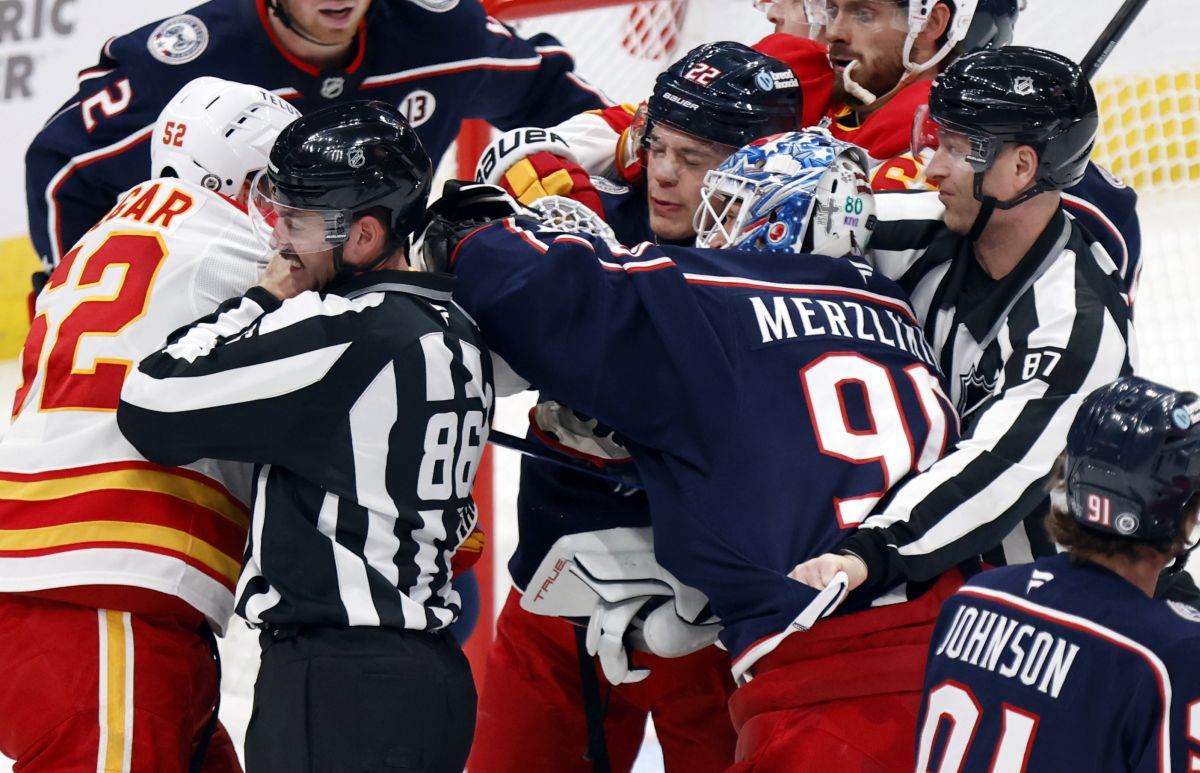 Columbus Blue Jackets goalie Elvis Merzlikins (90) is separated from Calgary Flames defenceman MacKenzie Weegar (52) by linesman Jesse Marquis (86), Blue Jackets defenceman Jordan Harris (22) and linesman Devin Berg (87) during the third period of an NHL hockey game in Columbus, Ohio, Friday, Nov. 29, 2024. Merzlikins was called for roughing.