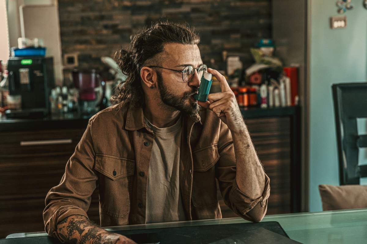 A man about to use an asthma inhaler.