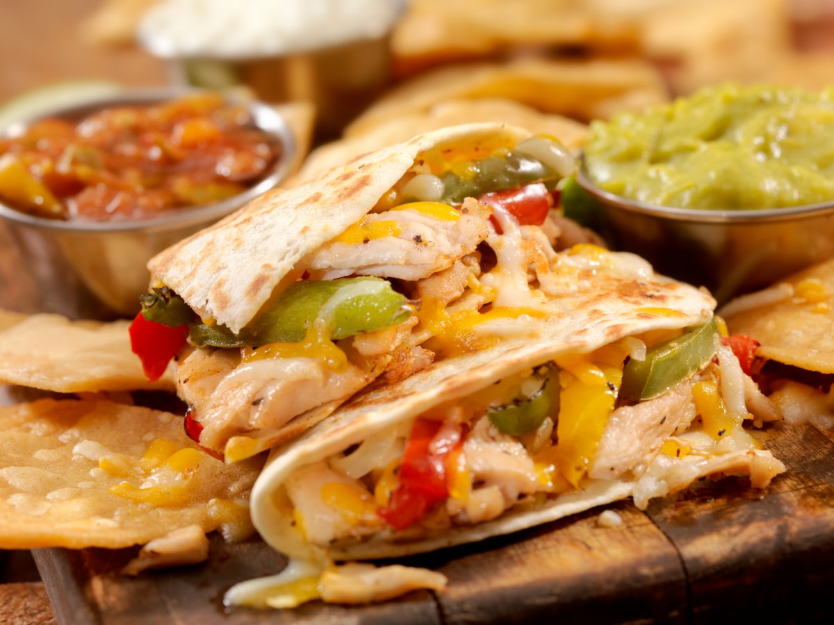 A chicken quesadilla between salsa and guacamole.