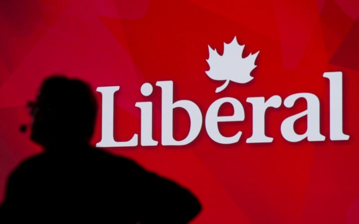 A Liberal Party of Canada logo is shown on a giant screen as a technician looks on during day one of the party's biennial convention in Montreal, Thusday, February 20, 2014.