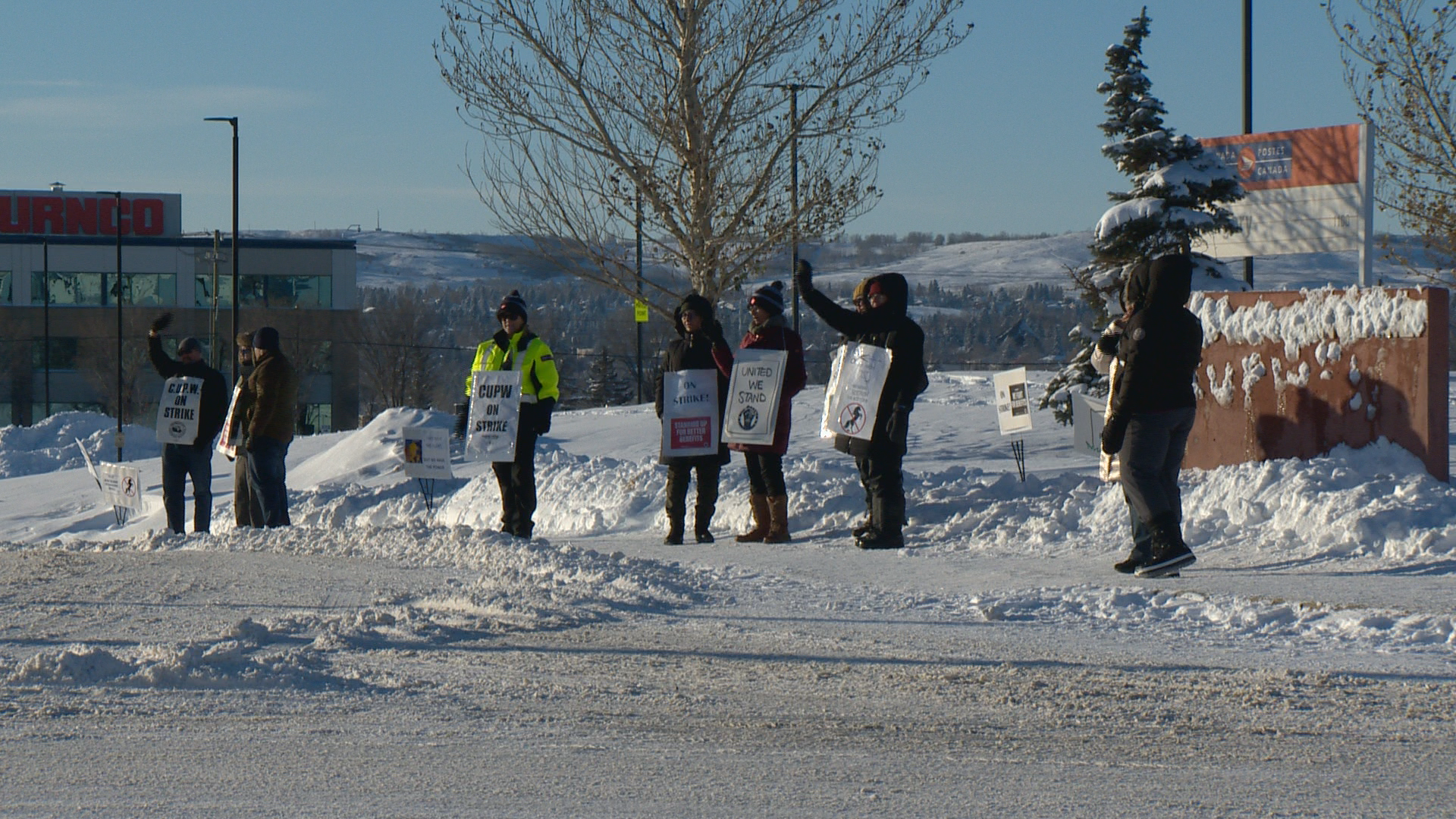 Canadian Union for Postal Workers members picket outside a Canada Post location