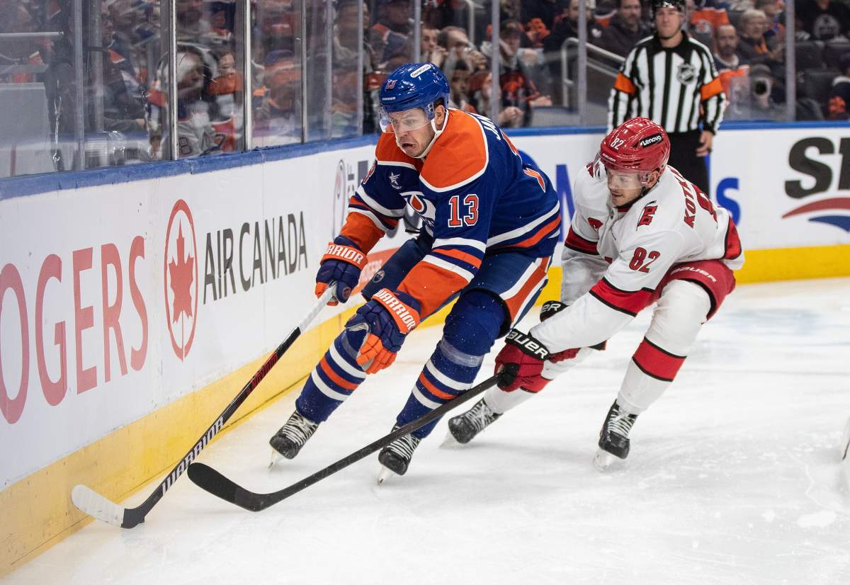 Carolina Hurricanes' Jesperi Kotkaniemi (82) and Edmonton Oilers' Mattias Janmark (13) battle for the puck during second period NHL action in Edmonton on Tuesday, October 22, 2024.