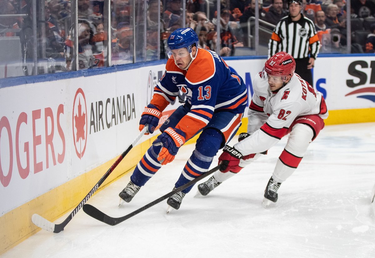 Carolina Hurricanes' Jesperi Kotkaniemi (82) and Edmonton Oilers' Mattias Janmark (13) battle for the puck during second period NHL action in Edmonton on Tuesday, October 22, 2024.