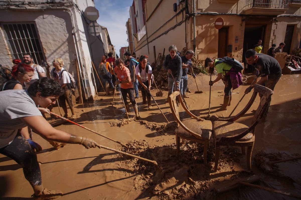 Residents and volunteers clean up an area affected by floods in Paiporta, near Valencia, Spain, Friday, Nov. 1, 2024. (AP Photo/Alberto Saiz)