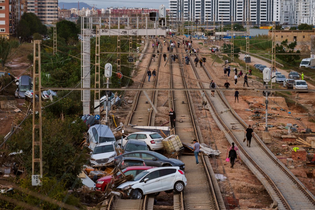 People walk along the train tracks heading toward Valencia in an area affected by floods in Sedavi, Spain, Friday, Nov. 1, 2024. (AP Photo/Manu Fernandez)