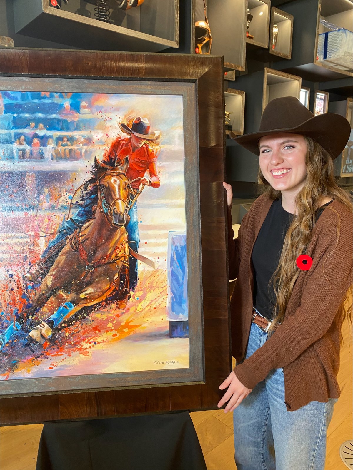 The winner of the 2025 Youth Stampede Poster competition, 22-year-old Elora Kiddle poses with her winning entry titled "From Grit to Greatness."