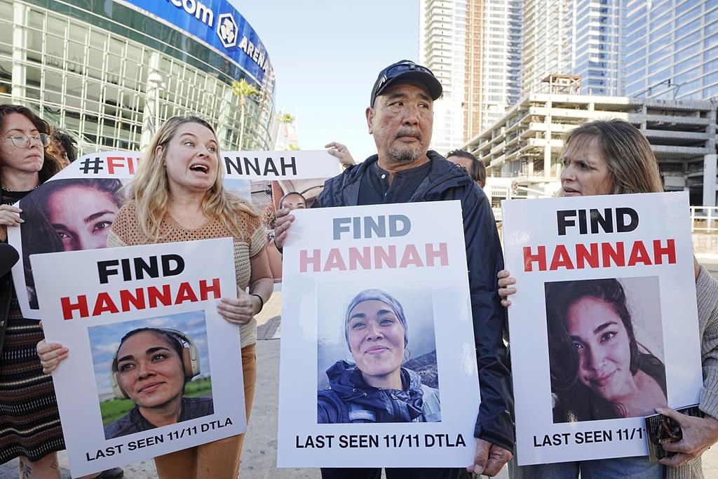 Ryan Kobayashi, center, holds a picture of his missing daughter Hannah Kobayashi outside Crypto.com Arena, Thursday, Nov. 21, 2024 in Los Angeles.