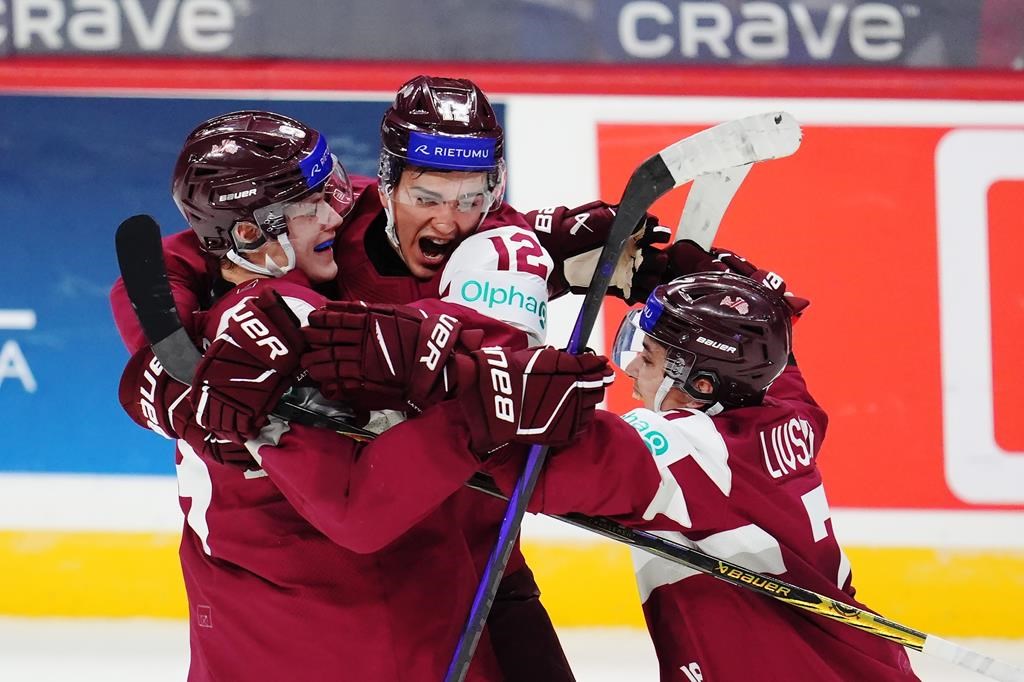 Latvia's Eriks Mateiko (left) celebrates his game-winning shootout goal against Canada with Toms Mots (12) and Davids Livsics (7) in IIHF World Junior Hockey Championship preliminary round action in Ottawa on Friday, Dec. 27, 2024.