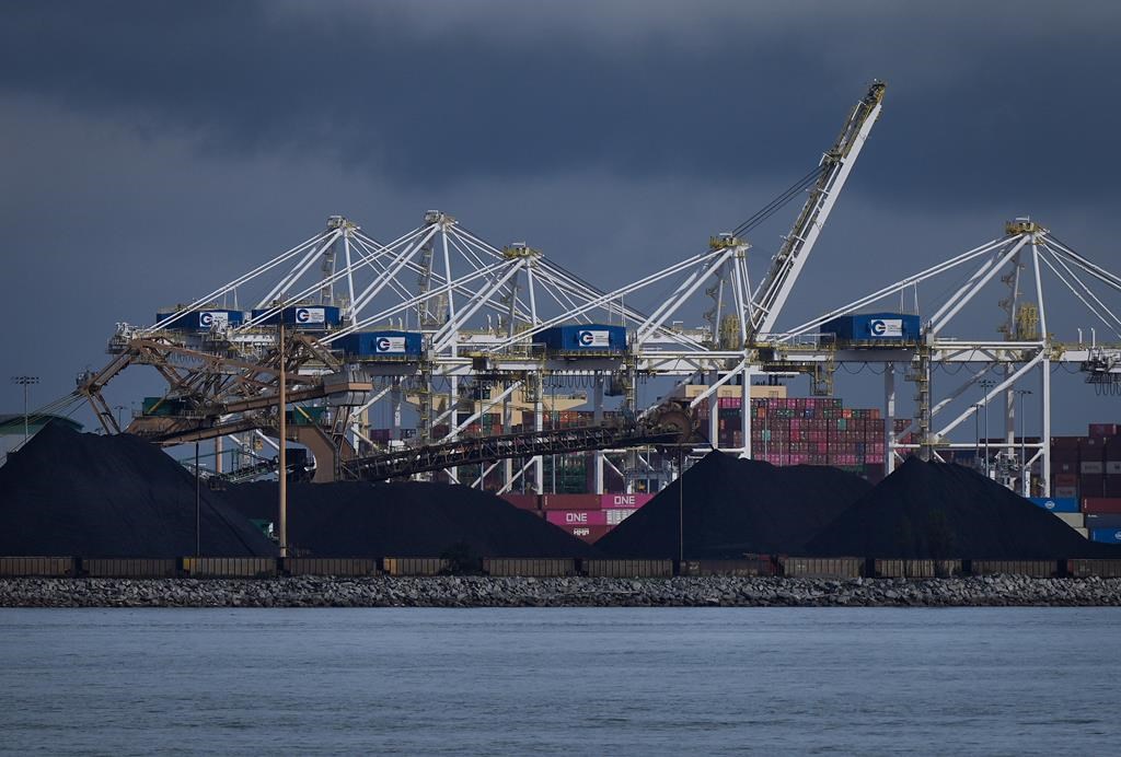 Piles of coal at the Westshore coal export terminal at Roberts Bank and gantry cranes used to load and unload containers onto and from cargo ships are seen at Deltaport, in Tsawwassen, B.C., on Monday, September 9, 2024.