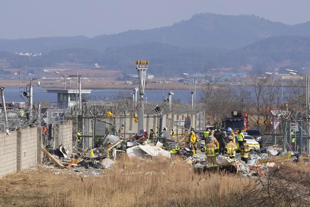 Firefighters and rescue team members work outside of Muan International Airport in Muan, South Korea, Sunday, Dec. 29, 2024.