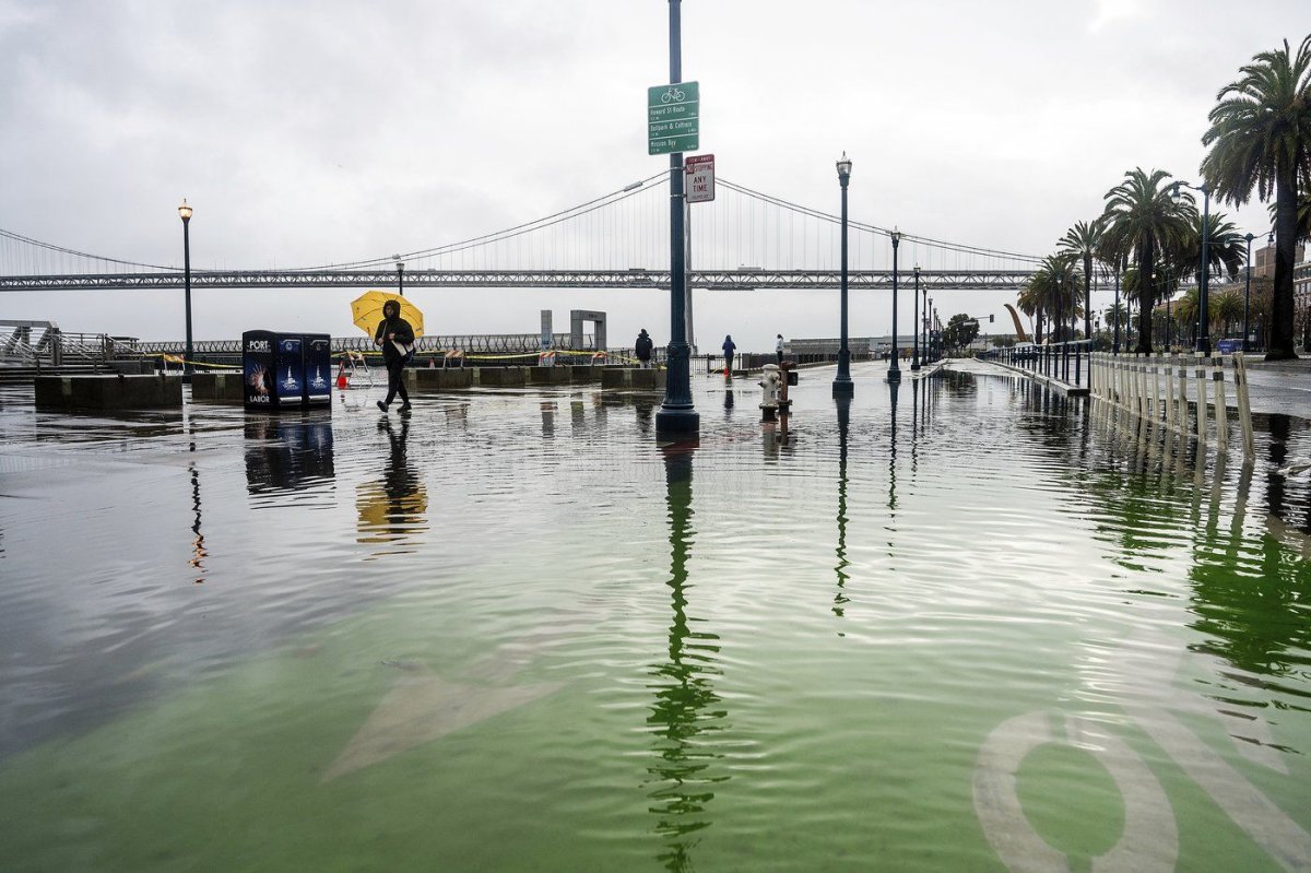 Water from the San Francisco Bay spills onto the Embarcadero as a result of high tides and storm-driven waves on Saturday, Dec. 14, 2024, in San Francisco. (AP Photo/Noah Berger)