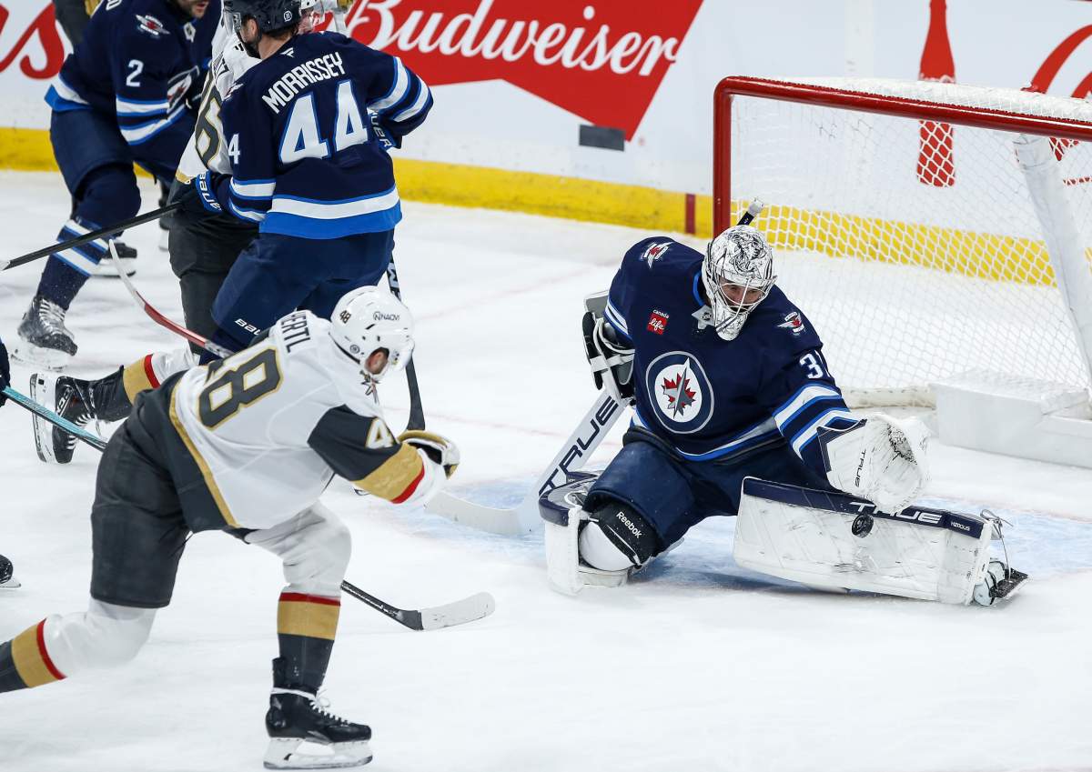 Winnipeg Jets goaltender Connor Hellebuyck (37) saves the backhander from Vegas Golden Knights' Tomas Hertl (48) during first period NHL action in Winnipeg, Thursday, Dec. 12, 2024.