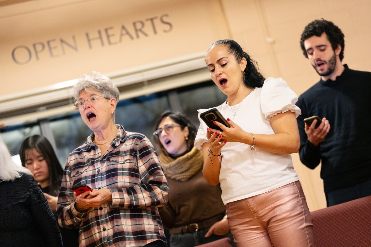 Members of the Halifax Newcomer Choir use a variety of smartphones and paper copies to read music during practice at St. Andrew's Church in Halifax, Tuesday, Dec. 17, 2024. The choir aims to provide English language practice and community building opportunities for newcomers and locals in the Halifax area. 