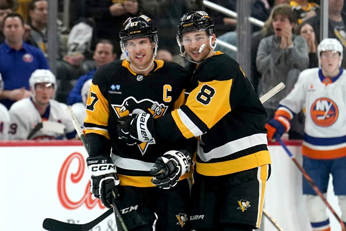 Pittsburgh Penguins’ Michael Bunting (8) celebrates with Sidney Crosby (87) after scoring during the second period of an NHL hockey game against the New York Islanders, Sunday, Dec. 29, 2024, in Pittsburgh.