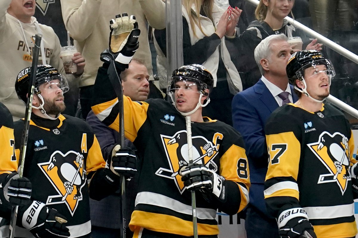 Pittsburgh Penguins’ Sidney Crosby, center, acknowledges the crowd after surpassing Mario Lemieux for the franchise record for most assists during the second period of an NHL hockey game against the New York Islanders, Sunday, Dec. 29, 2024, in Pittsburgh.