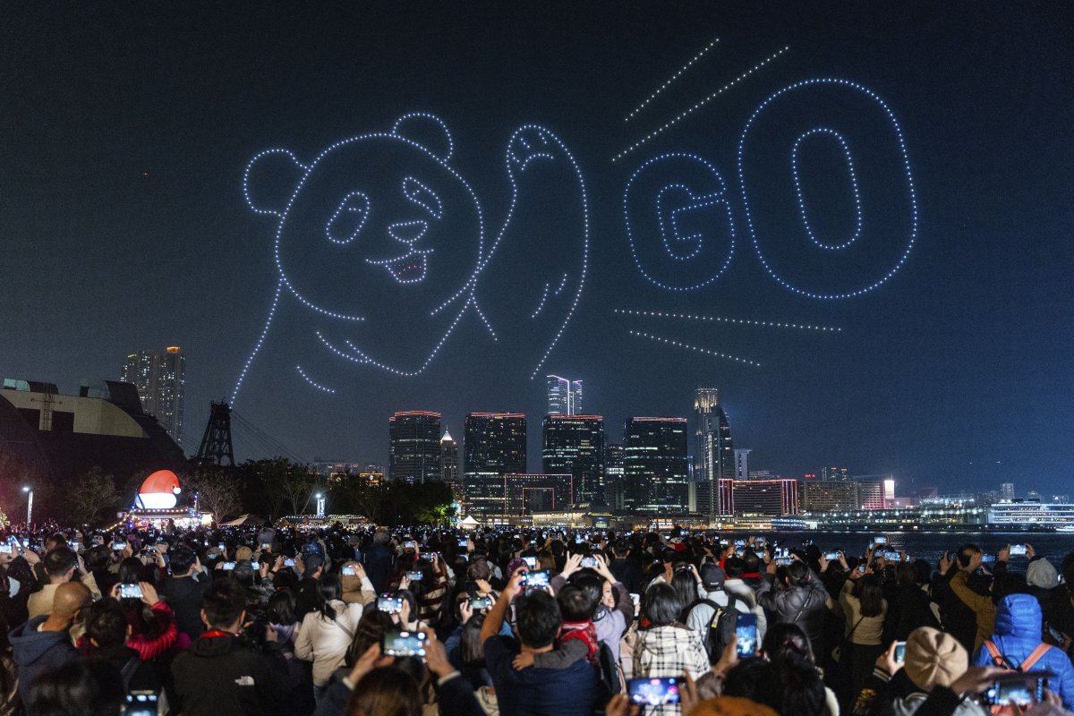 People watch the panda-themed drone show at the waterfront of the Victoria Harbour in Hong Kong, Saturday, Dec. 28, 2024.