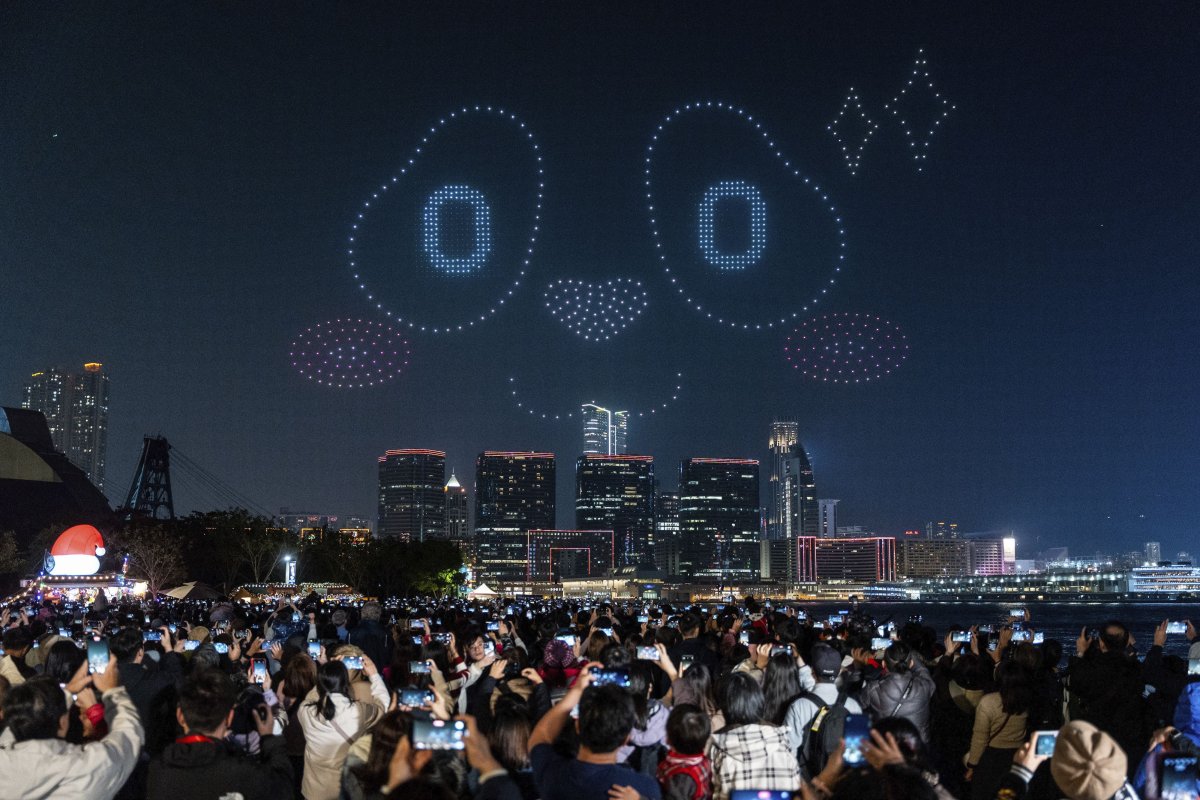 People watch the panda-themed drone show at the waterfront of the Victoria Harbour in Hong Kong, Saturday, Dec. 28, 2024.