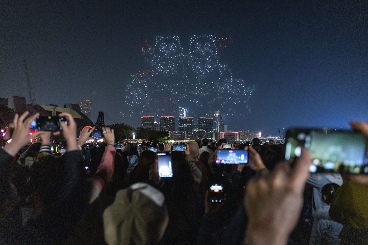 People watch the panda-themed drone show at the waterfront of the Victoria Harbour in Hong Kong, Saturday, Dec. 28, 2024.