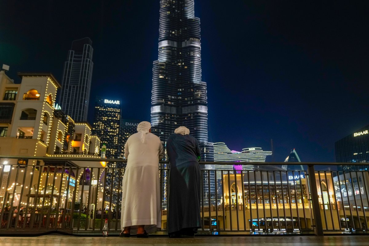 Emirati men stand on promenade in front of Burj Khalifa, the world's tallest building, ahead of the New Year's Eve celebration, in Dubai