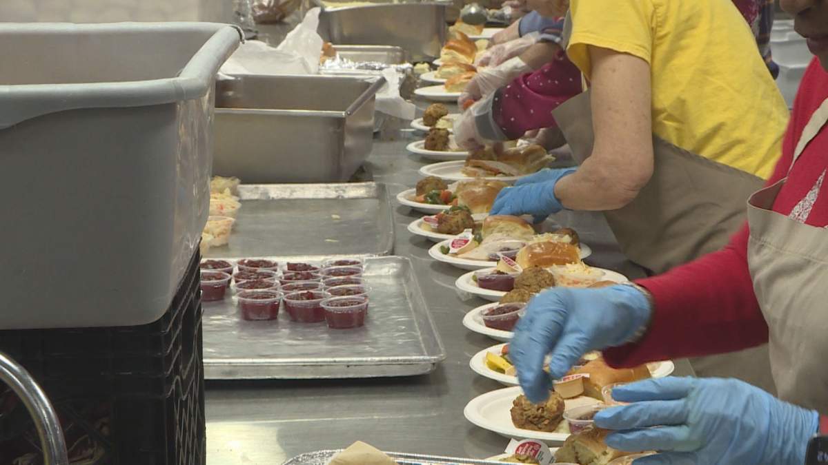 Volunteers at Siloam Mission work in an assembly line, preparing a Christmas lunch for vulnerable people.