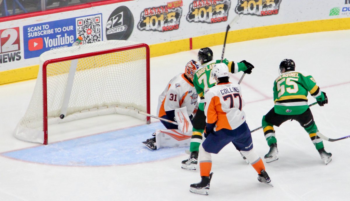 Noah Abolflan of the London Knights deflects a puck past Nathan Day of the Flint Firebirds in a game played on Dec. 29, 2024.