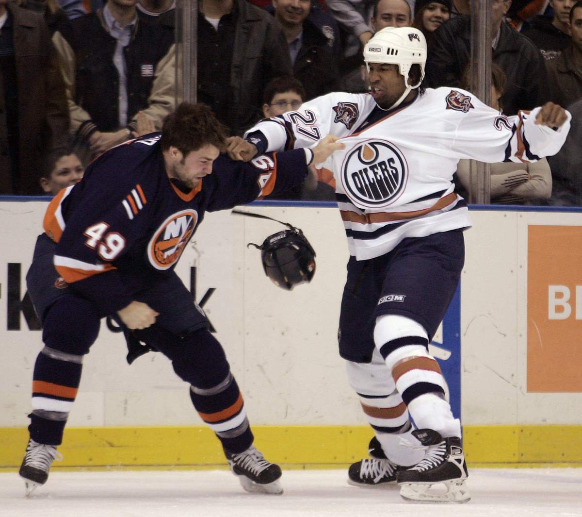 New York Islanders' Eric Godard, left, fights with Edmonton Oilers' Georges Laraque during the first period Saturday, Dec. 10, 2005, at Nassau Coliseum in Uniondale, N.Y.