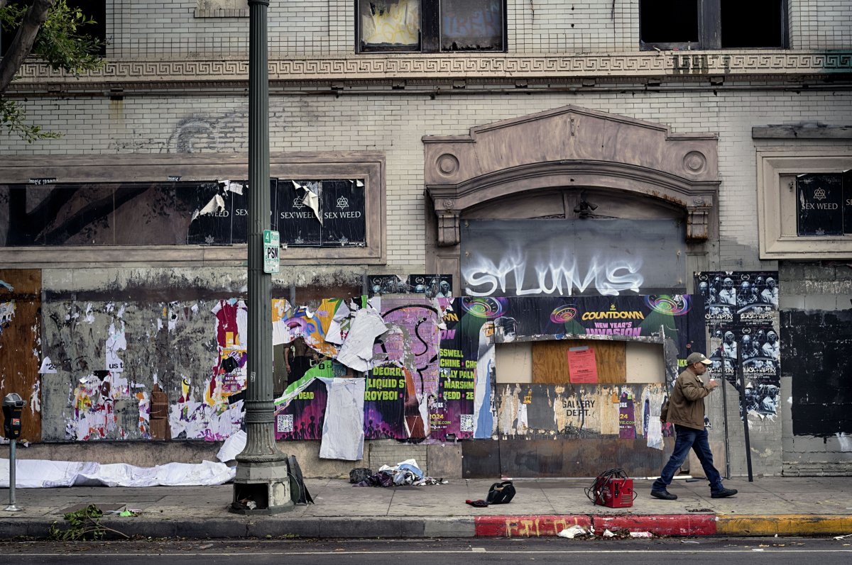 A worker walks past the entrance to the remains of the former Morrison Hotel after a fire on the 1200 block of South Hope Street in Los Angeles on Friday, Dec. 27, 2024.