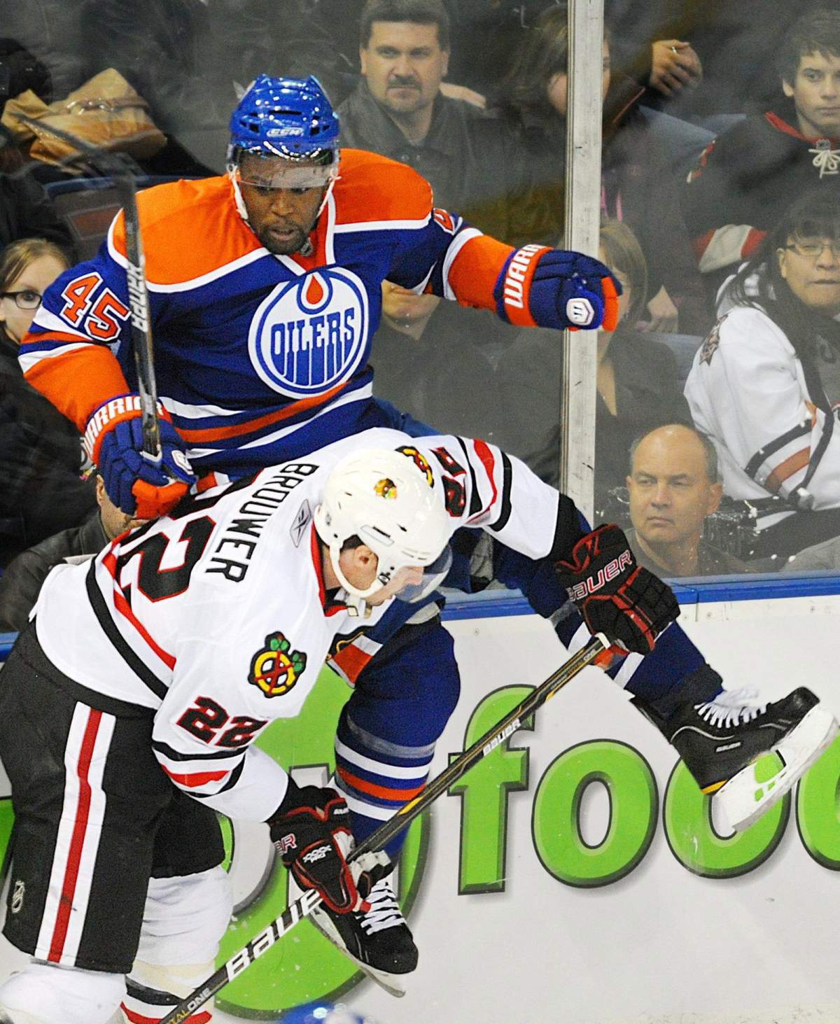 Chicago Blackhawks' Troy Brouwer, left, checks, Edmonton Oilers' Shawn Belle during second period NHL hockey action in Edmonton on Wednesday, November 17, 2010.
