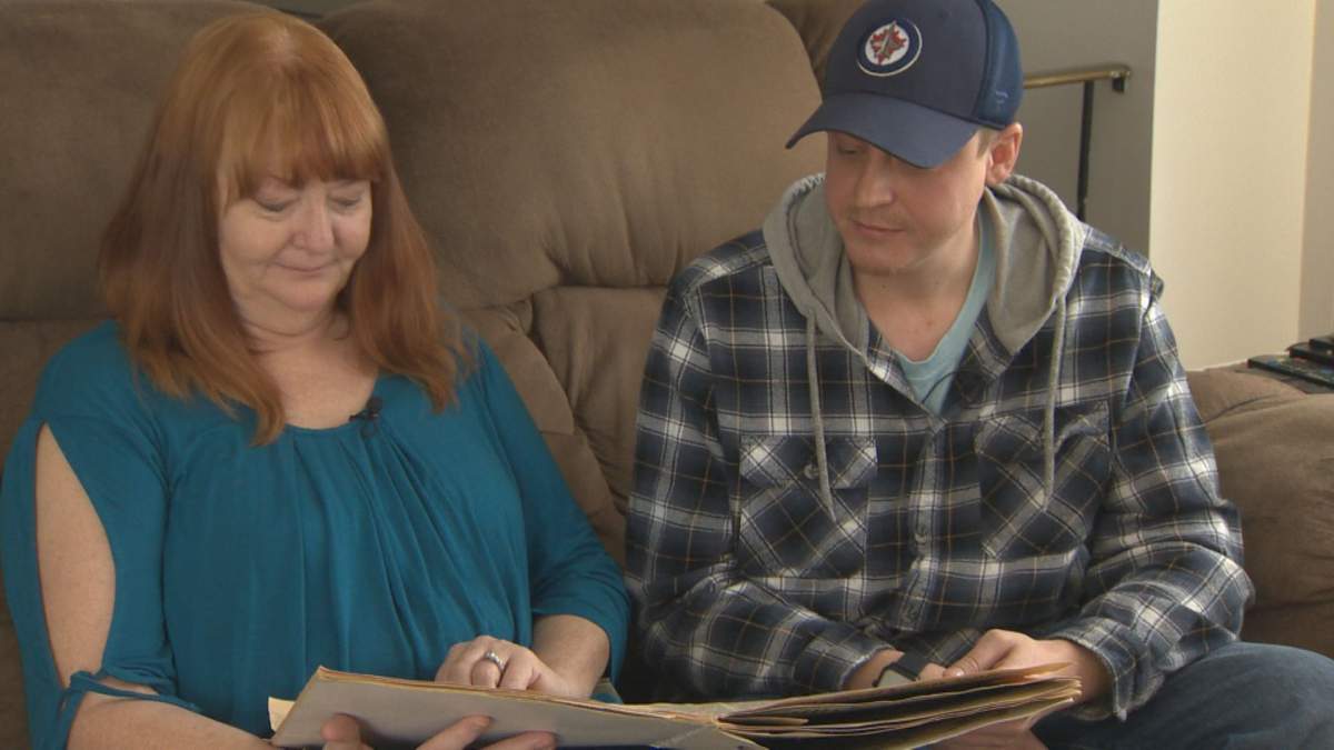 Cathie Bernd and son Justin Markus look through a scrap book while reflecting on the derailment that made them evacuate their home in 1992.