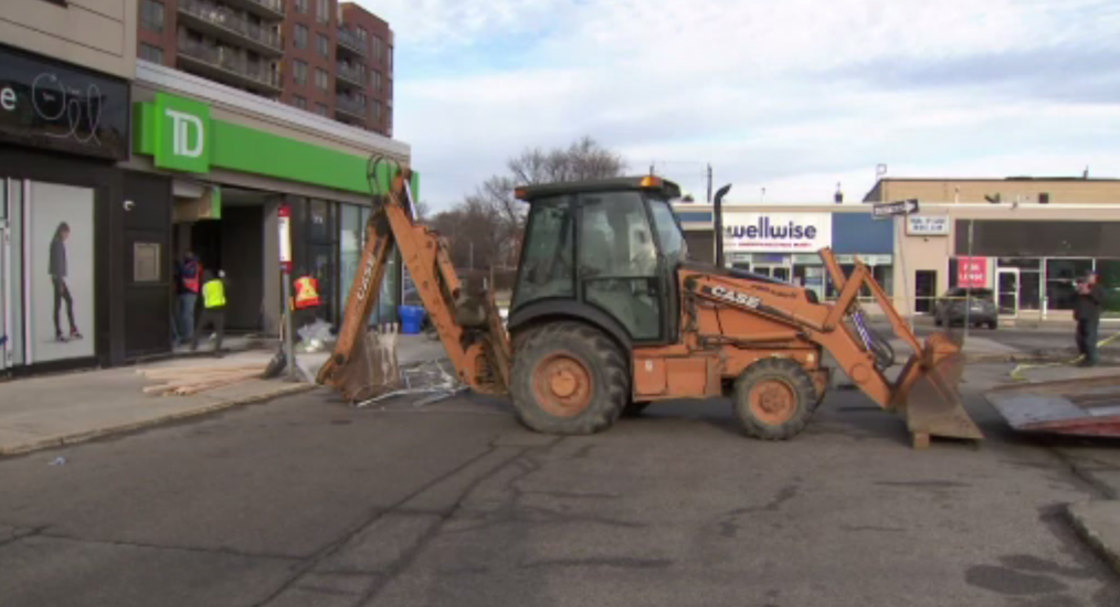 A backhoe at the scene of a damaged bank, ATM taken.