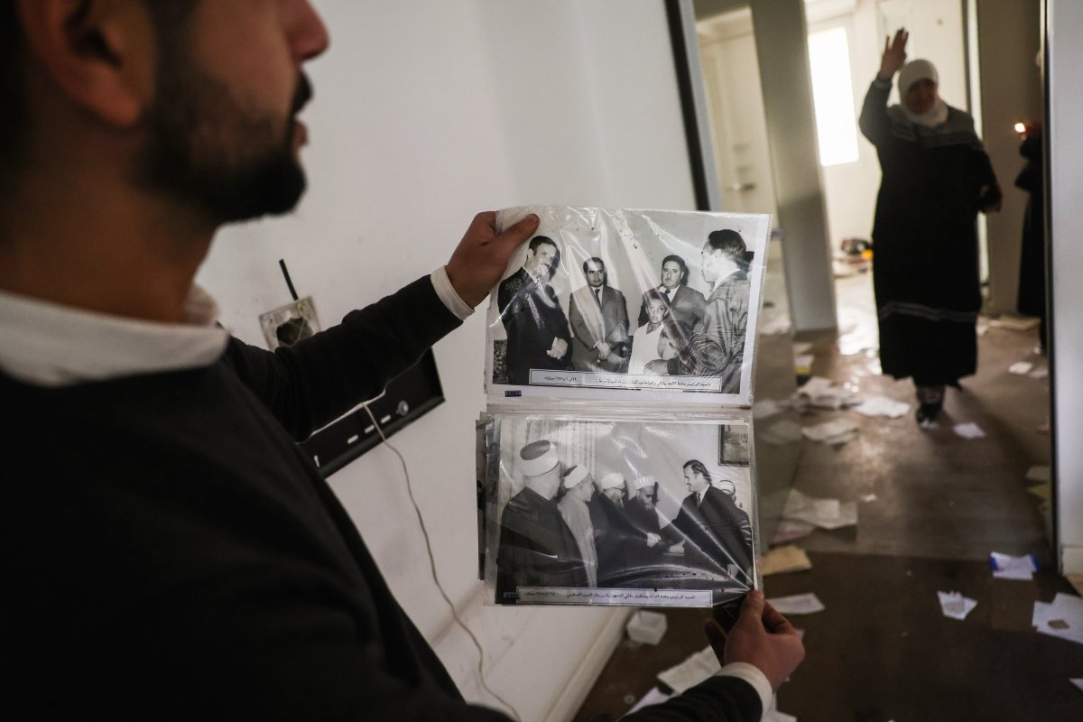 FILE.- A man shows old pictures of the late Syrian President Hafez Assad as civilians ransack the private residence of overthrown President Bashar Assad in the Malkeh district of Damascus, Syria, on Sunday, Dec. 8, 2024.