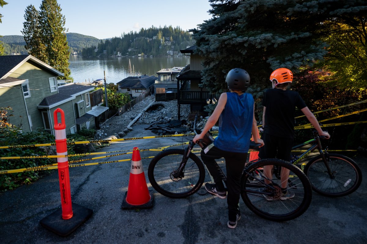 A home and vehicle are surrounded by debris left by flooding from an atmospheric river weather system at Deep Cove in North Vancouver, on Tuesday, October 22, 2024. T