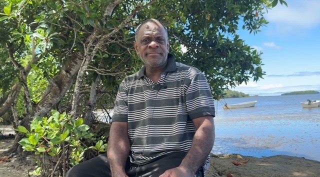 Nasilai Village leader Savenaca Delai sits on the sea wall built by his great grandfather to prevent flooding.