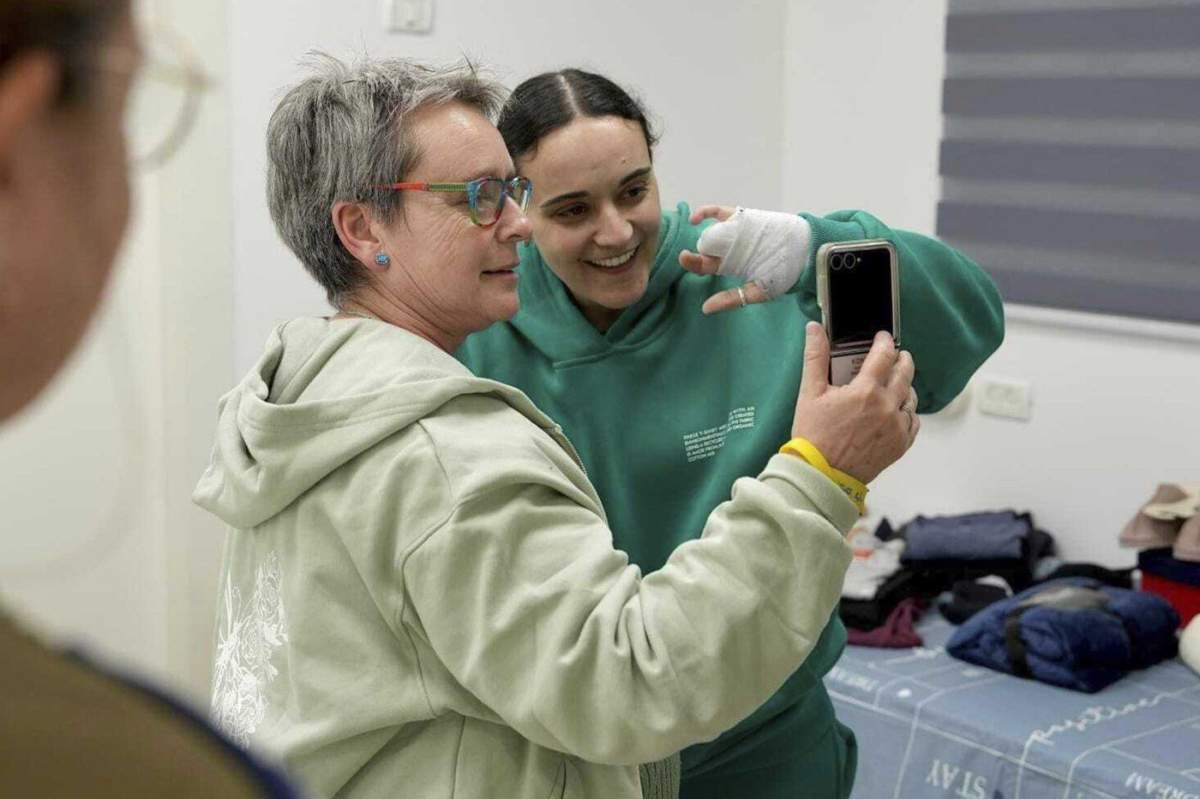 In this photo released by the Israeli Army, Emily Damari, right, and her mother Mandy use a smart phone near kibbutz Reim, southern Israel after Emily was released from captivity by Hamas militants in Gaza, Sunday, Jan. 19, 2025. (Israeli Army via AP) Uncredited